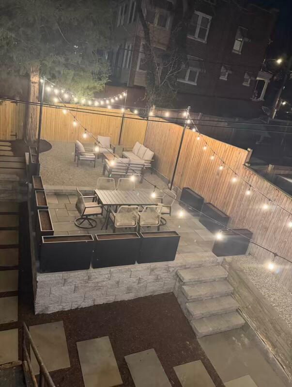 The Cozy Quarters backyard patio at night under string lights